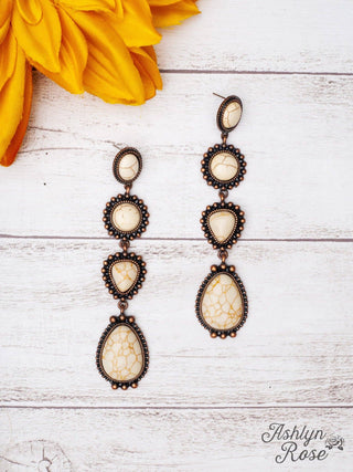 Flat lay of Along The Trail Cream Howlite Rock Copper Dangle Earrings by GRACE+EMMA against a rustic background, highlighting the intricate design and natural beauty of the cream howlite stones.