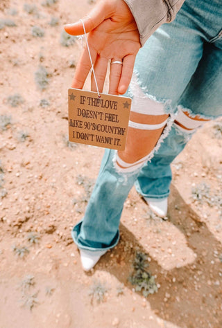A person displaying a 90's Country Car Air Freshener with a heartfelt message, perfect for fans of 90s country music and adding charm to any space.
