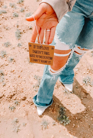 Close-up of a person holding a 90's Country Car Air Freshener that expresses a deep connection to 90s country music, showcasing its nostalgic design and appeal.